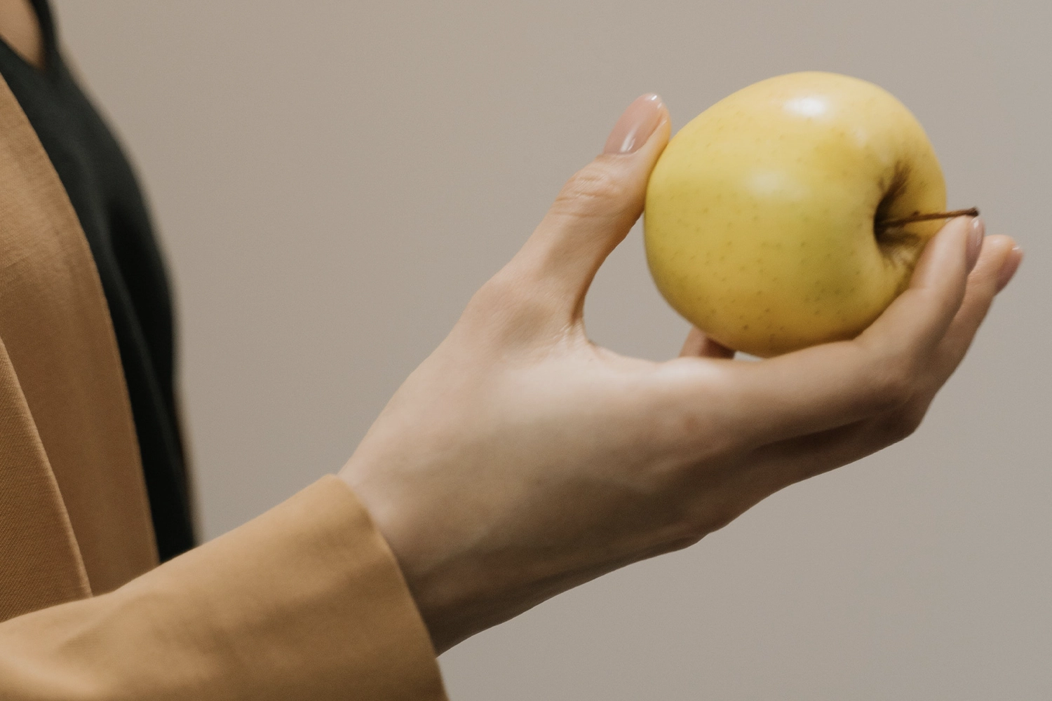 hand holding yellow apple